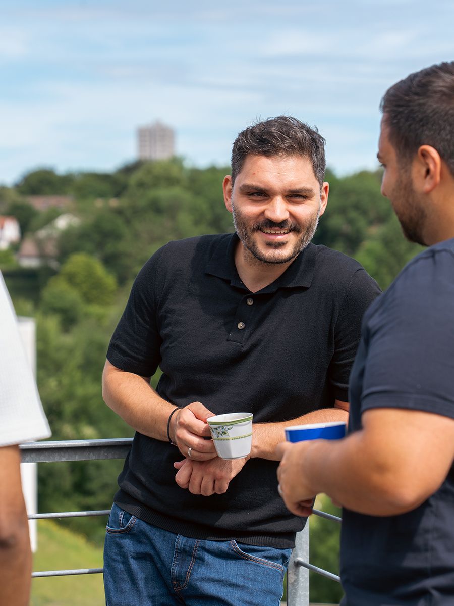 Zwei Kollegen im Gespräch auf der Terrasse